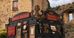 Affiche de La Monstrerie Moriboum, théâtre de curiosité ambulant installé dans une caravane décorée.