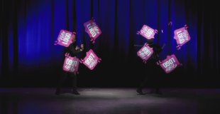 Performance de jonglerie LED graphique avec logos personnalisés pour un dîner de gala corporate.